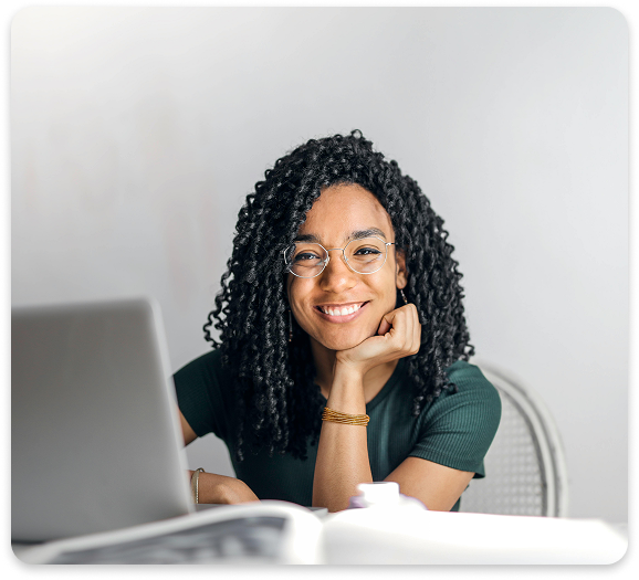 Empowered by CBT – Building Focus, Emotional Strength, and Self-Awareness Smiling person sitting at a desk with a laptop, symbolizing confidence and clarity from CBT.