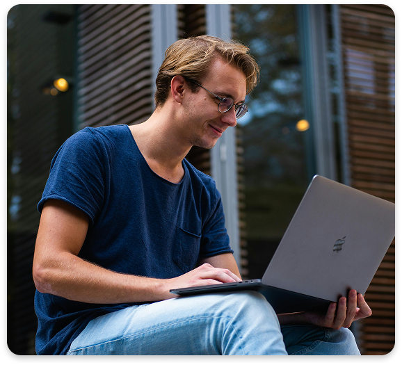 Telemedicine for Flexible, Consistent Mental Health Support Smiling young man using a laptop outdoors for a virtual psychiatric consultation.