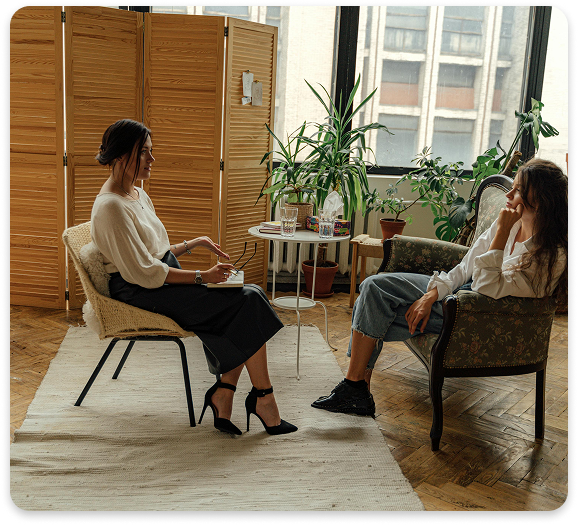 Comfortable Setting for a Personalized Psychiatric Evaluation Therapist and client in a calm, plant-filled office during a one-on-one mental health consultation.