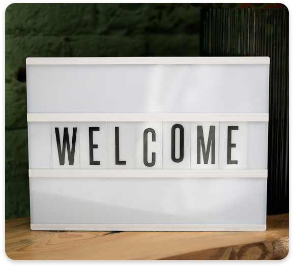 Welcome to Regions Praxis Care – Inclusive Mental Health Services Lightbox with the word "WELCOME" displayed on a wooden table in a therapy office